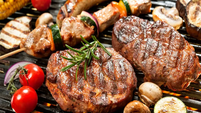 Assorted delicious grilled meat with vegetable over the coals on a barbecue Assorted delicious grilled meat with vegetable over the coals on a barbecue