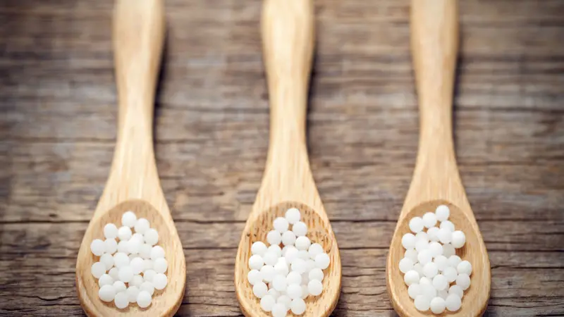 Three woodens spoon of homeopathic globules. Three woodens spoon of homeopathic globules.