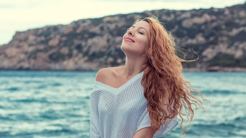 Woman on the beach enjoying fresh air