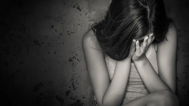 Black and white grunge image of a beautiful teenage girl sitting on the floor crying Black and white grunge image of a beautiful teenage girl sitting on the floor crying