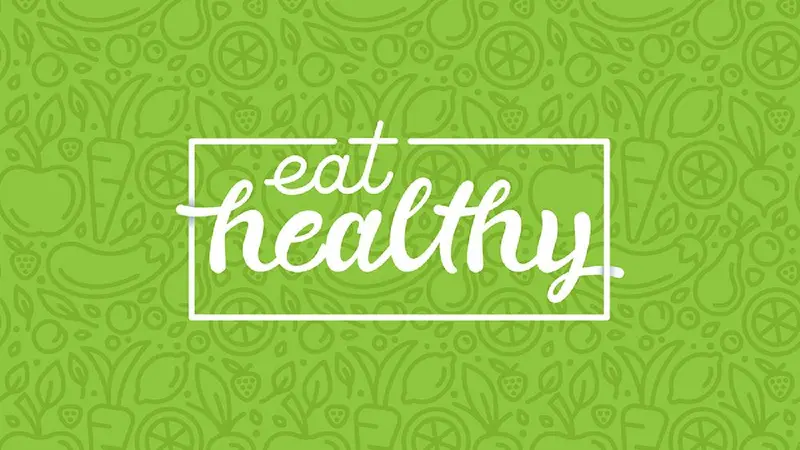 Banner with hand-lettering phrase eat healthy on green background with signs of fruits and vegetables