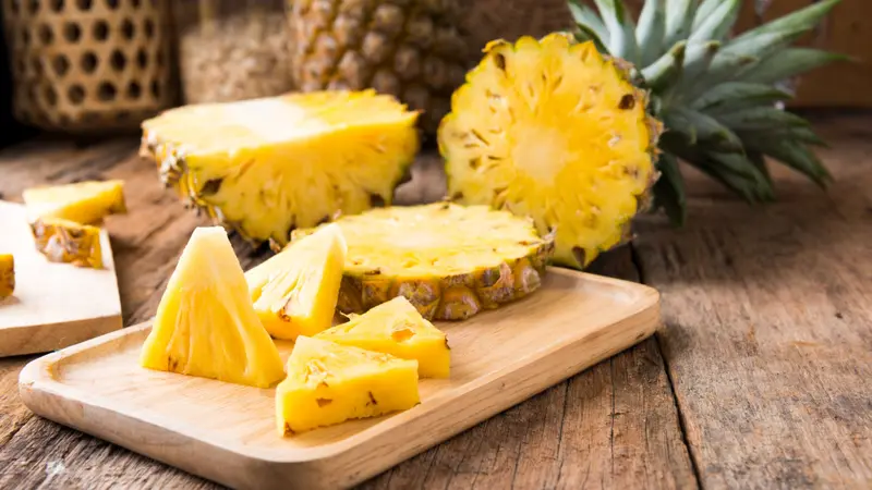 Cut pineapple on the wooden background