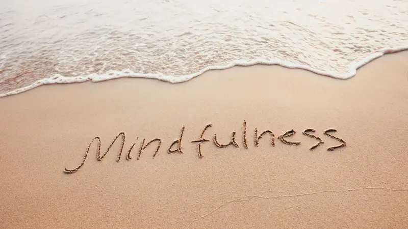 Mindfulness concept, text written on the sand of beach Mindfulness concept, text written on the sand of beach