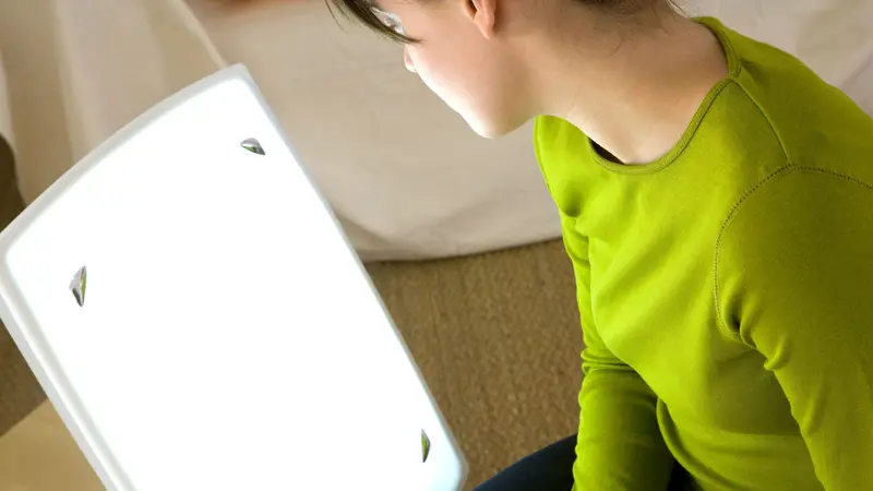 Woman using light therapy Woman using light therapy