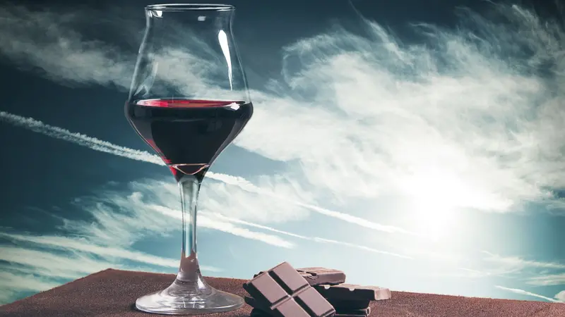 Wine glass and chocolate with blue cloudscape