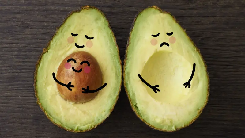 An avocado parent and child in embrace beside another avocado who is sad that is it without a child or baby