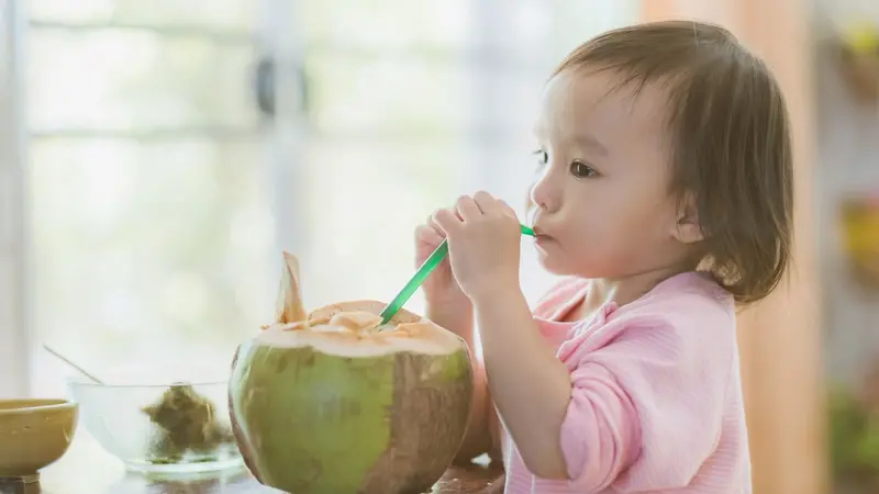 Child drinking from a coconut