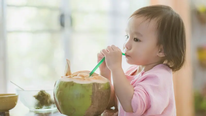 Child drinking from a coconut Child drinking from a coconut