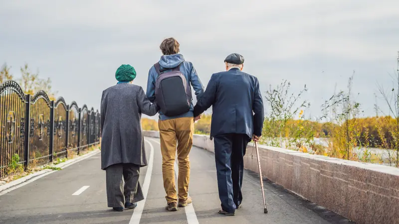 Helping an elderly couple walk in the park