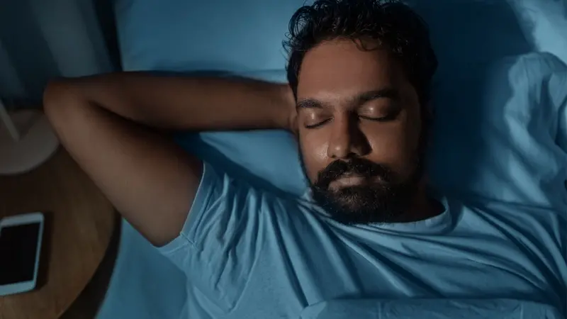 Indian man sleeping in bed at home at night Indian man sleeping in bed at home at night