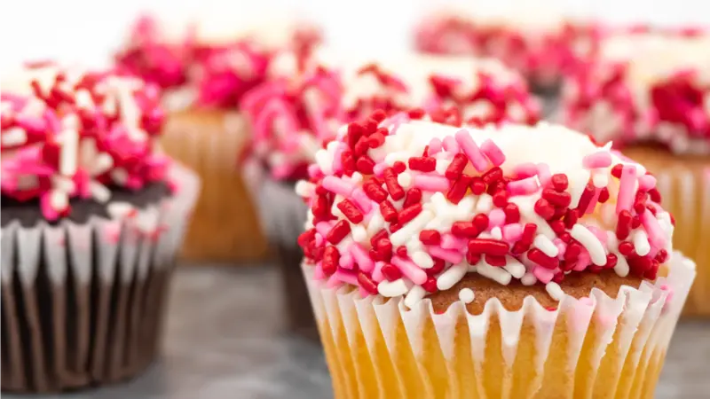 Tray Full of Vanilla and Chocolate Cupcakes Decorated with White Frosting and Red, White and Pink Sprinkles Tray Full of Vanilla and Chocolate Cupcakes Decorated with White Frosting and Red, White and Pink Sprinkles