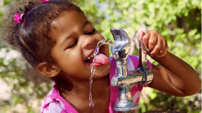 Child Drinking From Outdoor Water Fountain