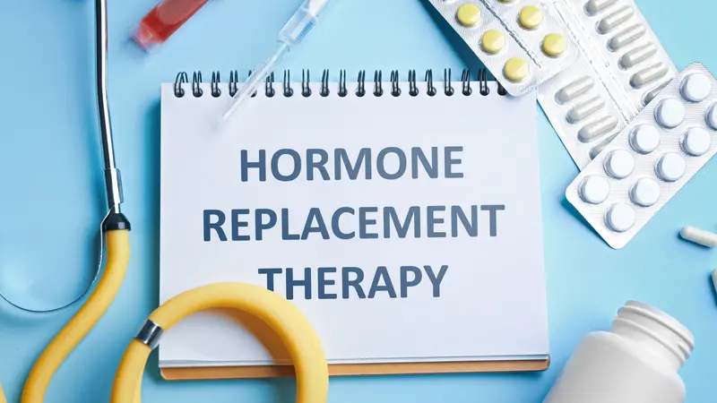 Notebook with text Hormone Replacement Therapy and medications on light blue background Notebook with text Hormone Replacement Therapy and medications on light blue background