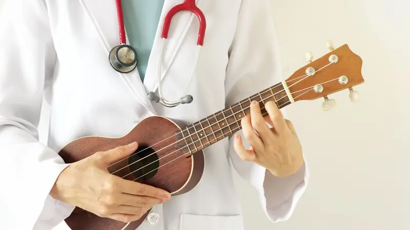 Doctor playing ukulele, Music therapy concept Doctor playing ukulele, Music therapy concept