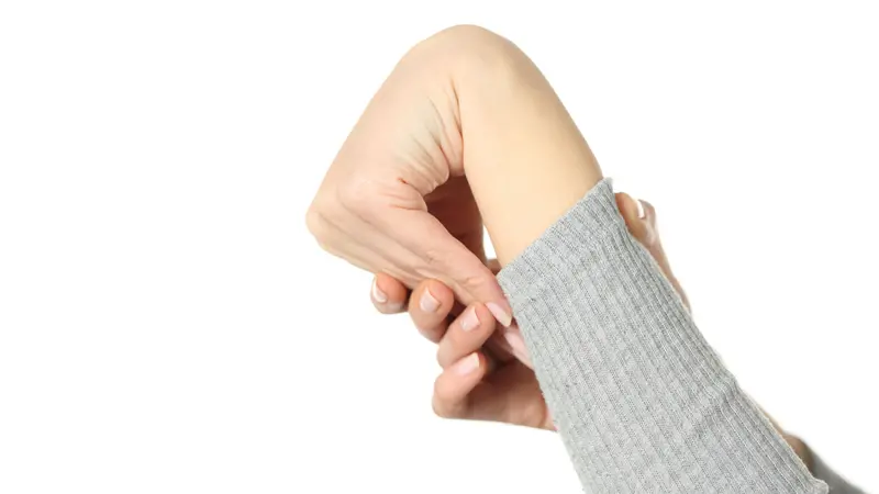 Close up of hypermobile woman hand bending wrist isolated on white background Close up of hypermobile woman hand bending wrist isolated on white background