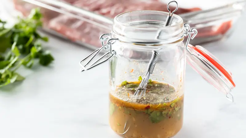 Close up of a small jar filled with a marinade mixture