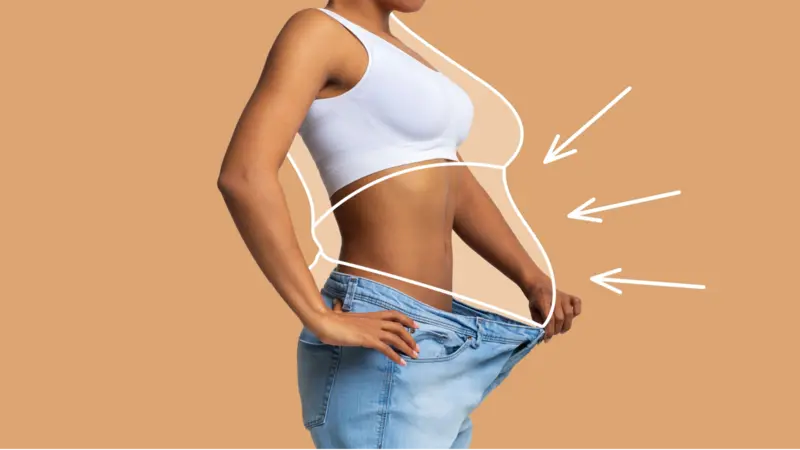Young slim African American female in big jeans enjoy weight loss result with fat abstract body around, arrows isolated on beige wall background Young slim African American female in big jeans enjoy weight loss result with fat abstract body around, arrows isolated on beige wall background