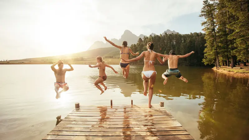 Young friends jumping into the water from a jetty. Young friends jumping into the water from a jetty.