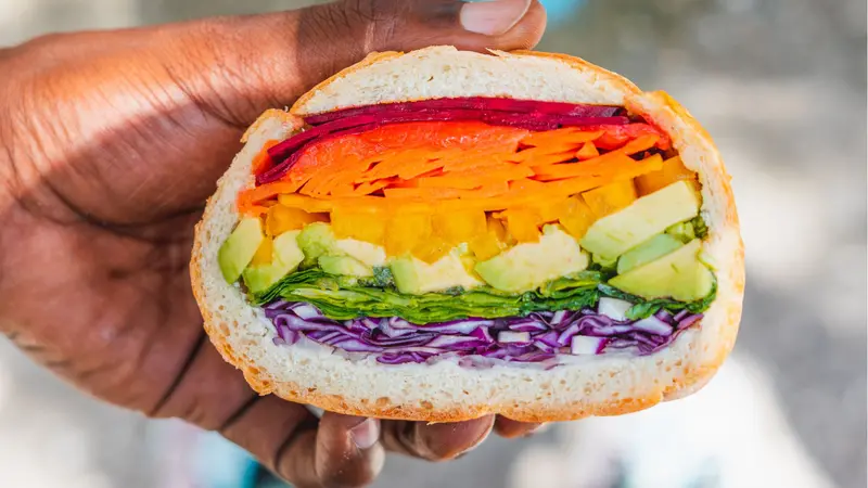 Man Holding Rainbow Vegan Veggie Sandwich