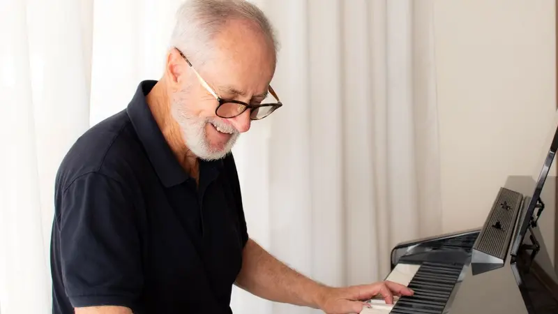 Man learning to play piano