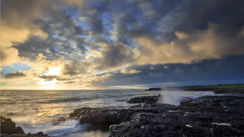 A rocky ocean shore of during sunset A rocky ocean shore of during sunset
