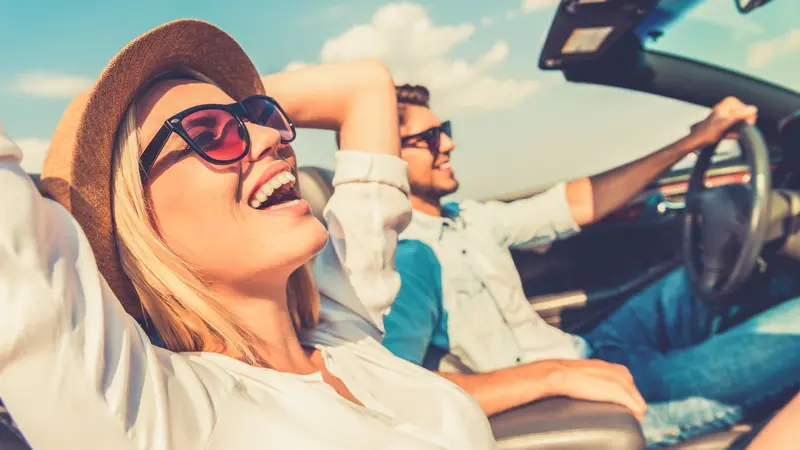 Couple driving in convertible car