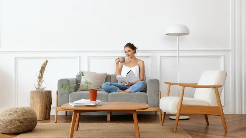 Woman reading a book in a minimalist living space