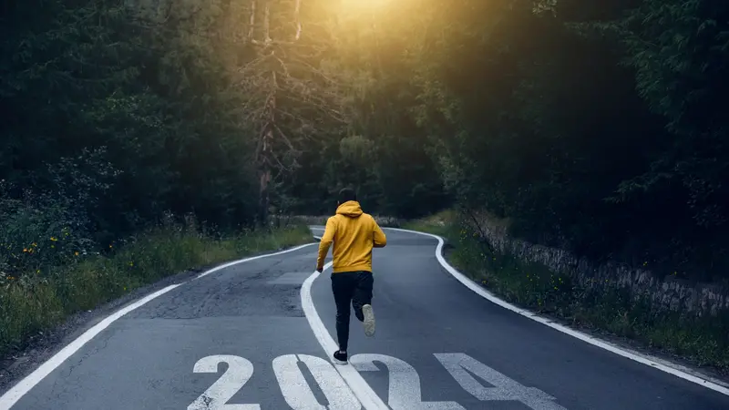 Man running on the mountain road towards new goals in 2024