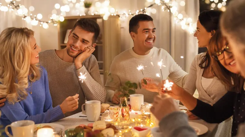 Happy family with sparklers having fun at dinner party at home