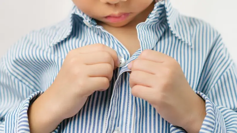 Close up of a little kindergarten boy's hands learning to get dressed Close up of a little kindergarten boy's hands learning to get dressed