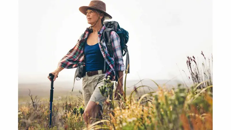 Senior woman on a hiking trip with the help of a trekking pole. Senior woman on a hiking trip with the help of a trekking pole.