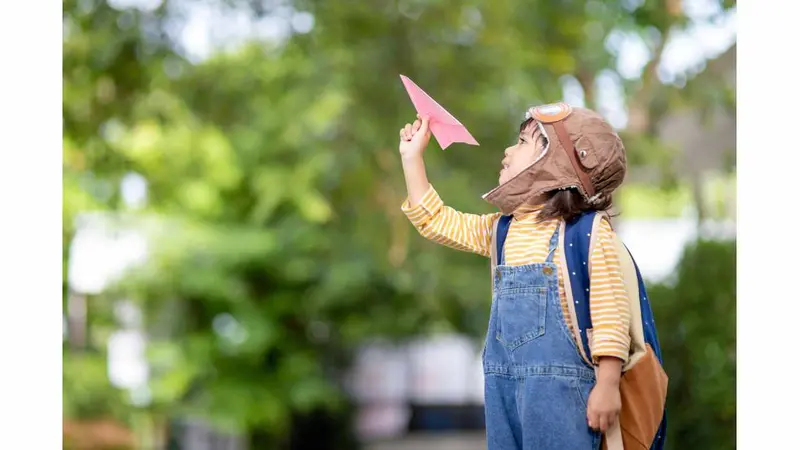 Little boy flying a paper airplane Little boy flying a paper airplane