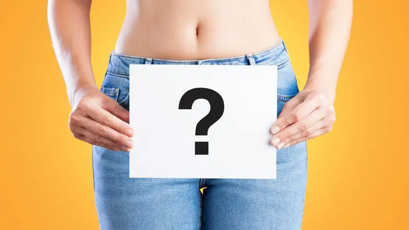 Young woman holding a paper with question mark on her waist Young woman holding a paper with question mark on her waist