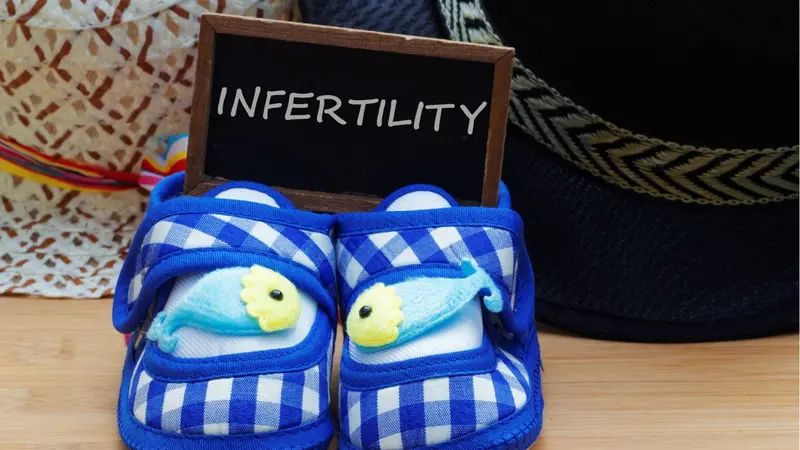 Infertility concept with blue baby shoes Infertility concept with blue baby shoes
