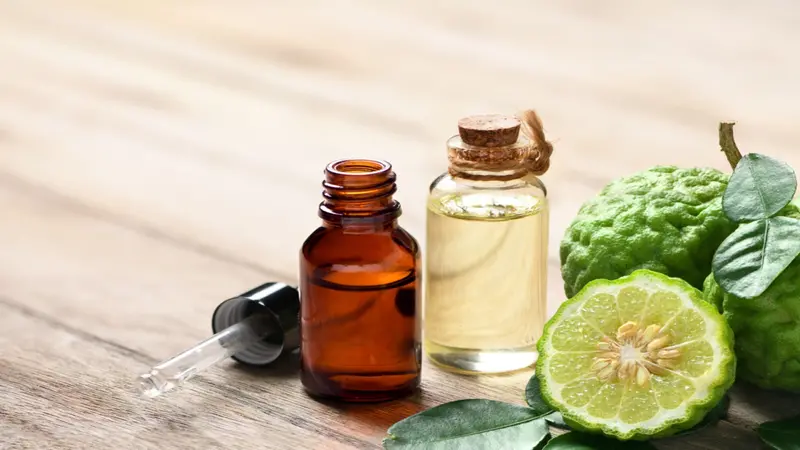 Bergamot essential oil with half cut and leaves on wooden table. Bergamot essential oil with half cut and leaves on wooden table.