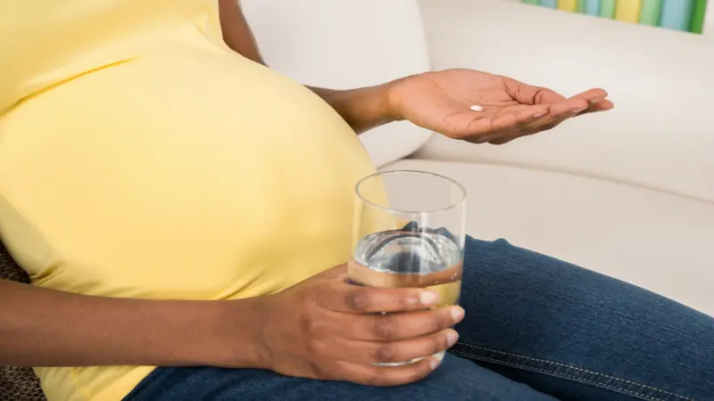 Close-up Of Pregnant Woman Holding Medicine With Glass Of Water At Home Close-up Of Pregnant Woman Holding Medicine With Glass Of Water At Home