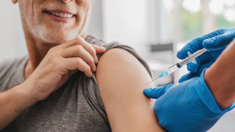 Doctor making injection to senior patient in clinic Doctor making injection to senior patient in clinic