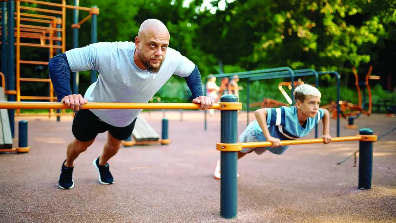 A man exercising together with his son A man exercising together with his son