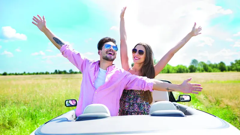A man and a woman standing side by side, arms outstretched A man and a woman standing side by side, arms outstretched