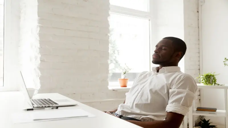 man meditating at his desk in front of the computer man meditating at his desk in front of the computer