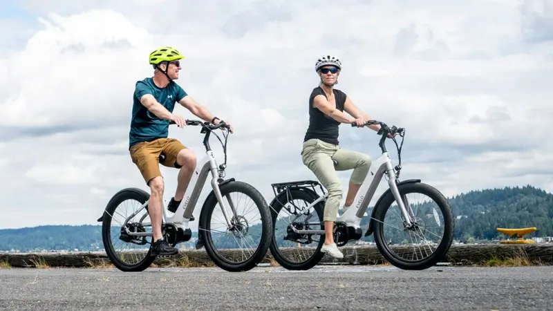 Man and woman riding electric bicycles Man and woman riding electric bicycles