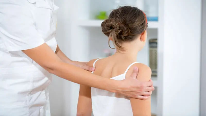 Chiropractor doing adjustment on young female pediatric patient Chiropractor doing adjustment on young female pediatric patient