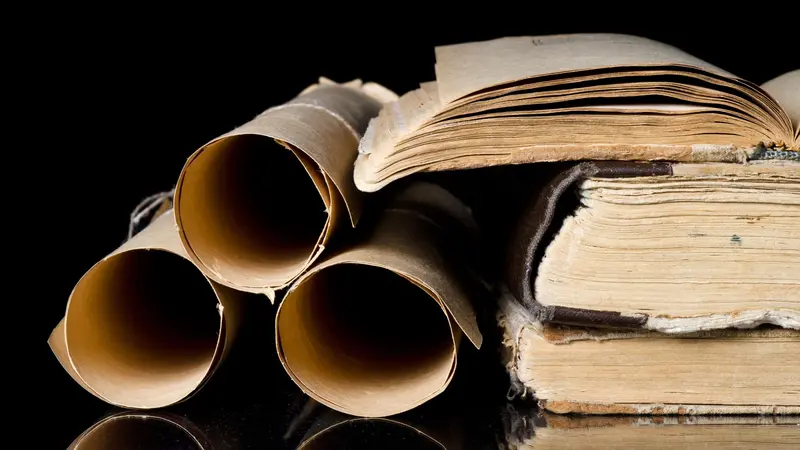 Many scrolls and old books on black background Many scrolls and old books on black background