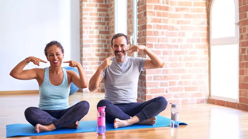 Woman and man doing yoga and pointing to their teeth