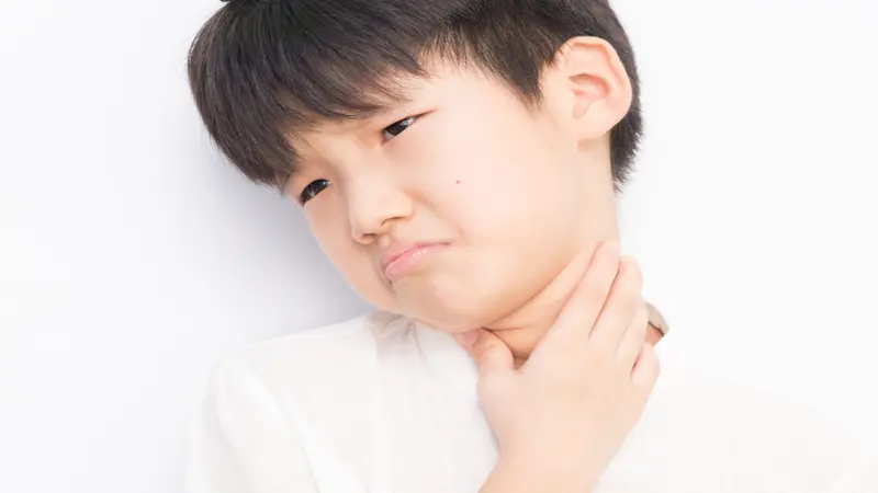 Boy holding his throat in pain, PANDAS arises from complications after strep throat Boy holding his throat in pain, PANDAS arises from complications after strep throat