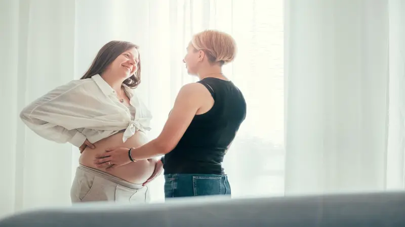 One person pregnant, looking at each other One person pregnant, looking at each other