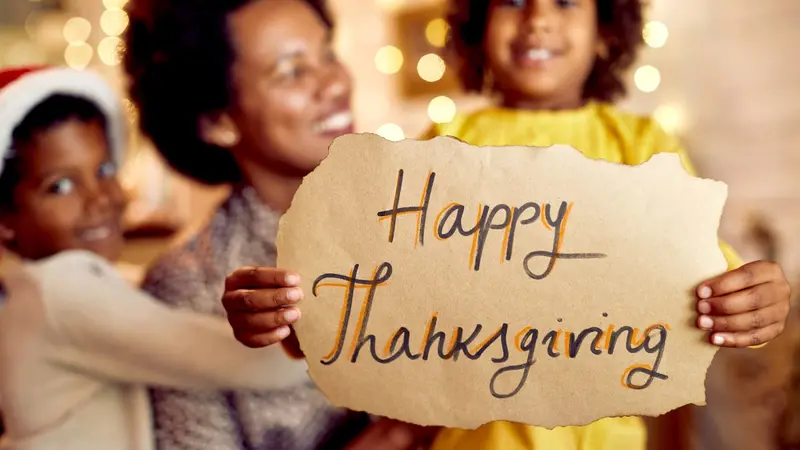 Girl holding a Happy Thanksgiving sign