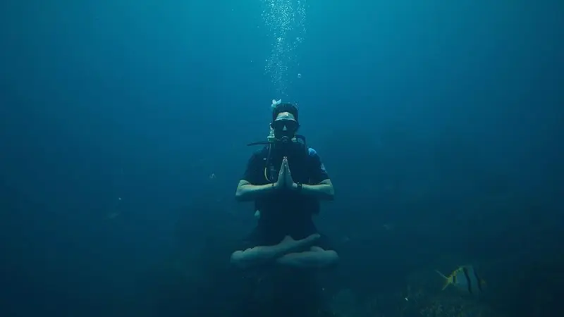 Person in lotus position while SCUBA diving