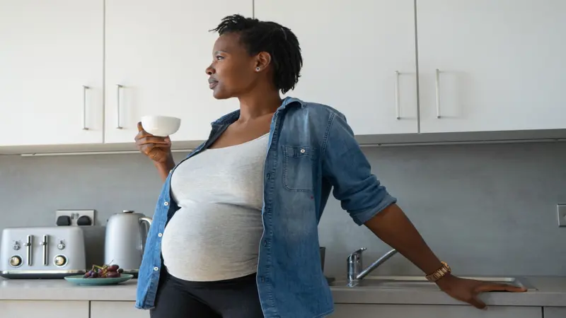 Pregnant Black woman drinking a cup of tea