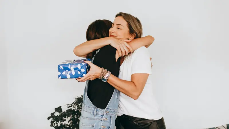 two women hugging, gratitude after receiving a gift